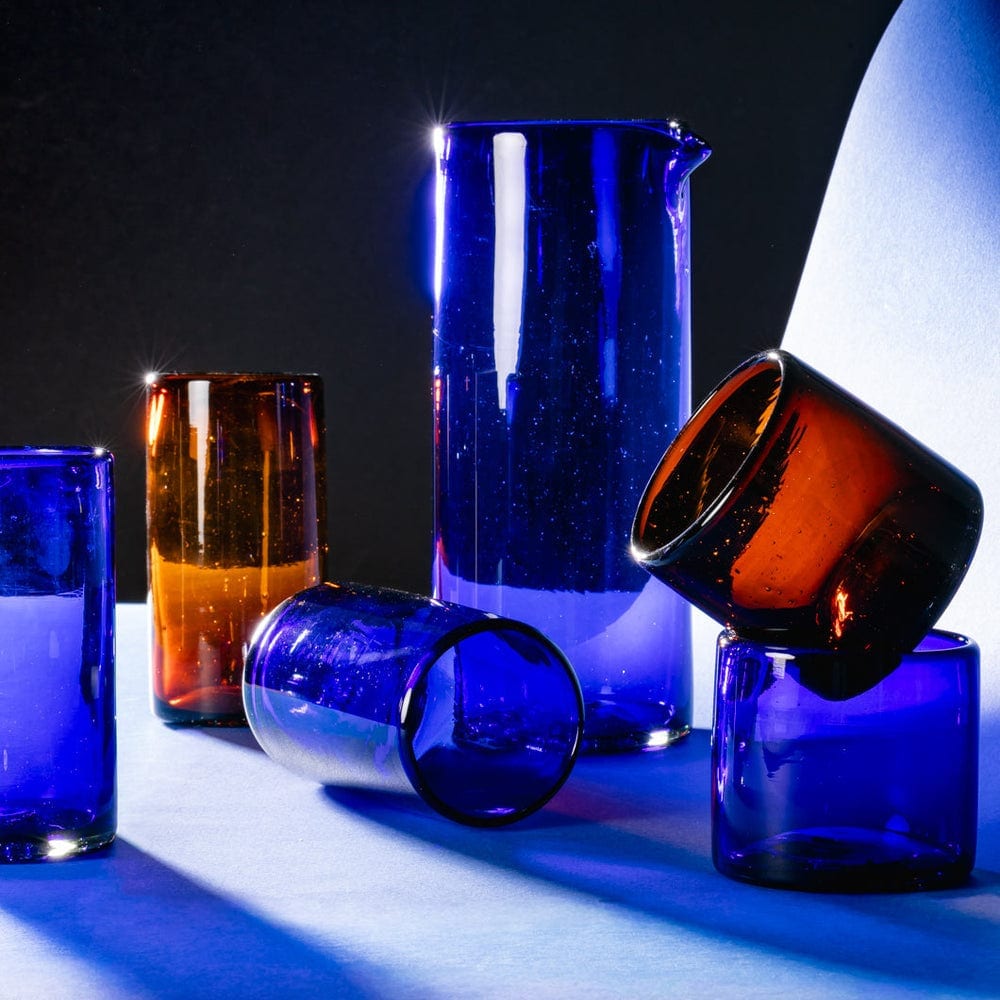 Cobalt blue and amber glass tumblers with a pitcher.