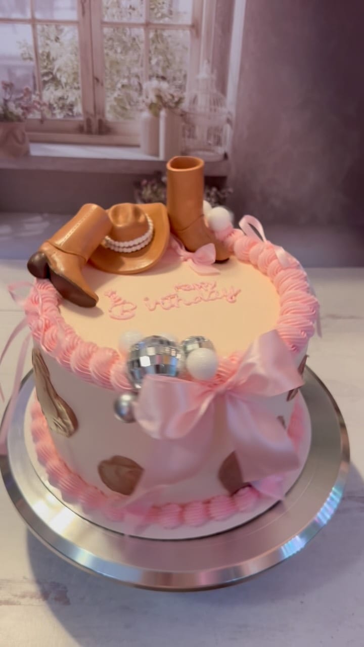 Pink heart-shaped custom cake with bows and piped decorations